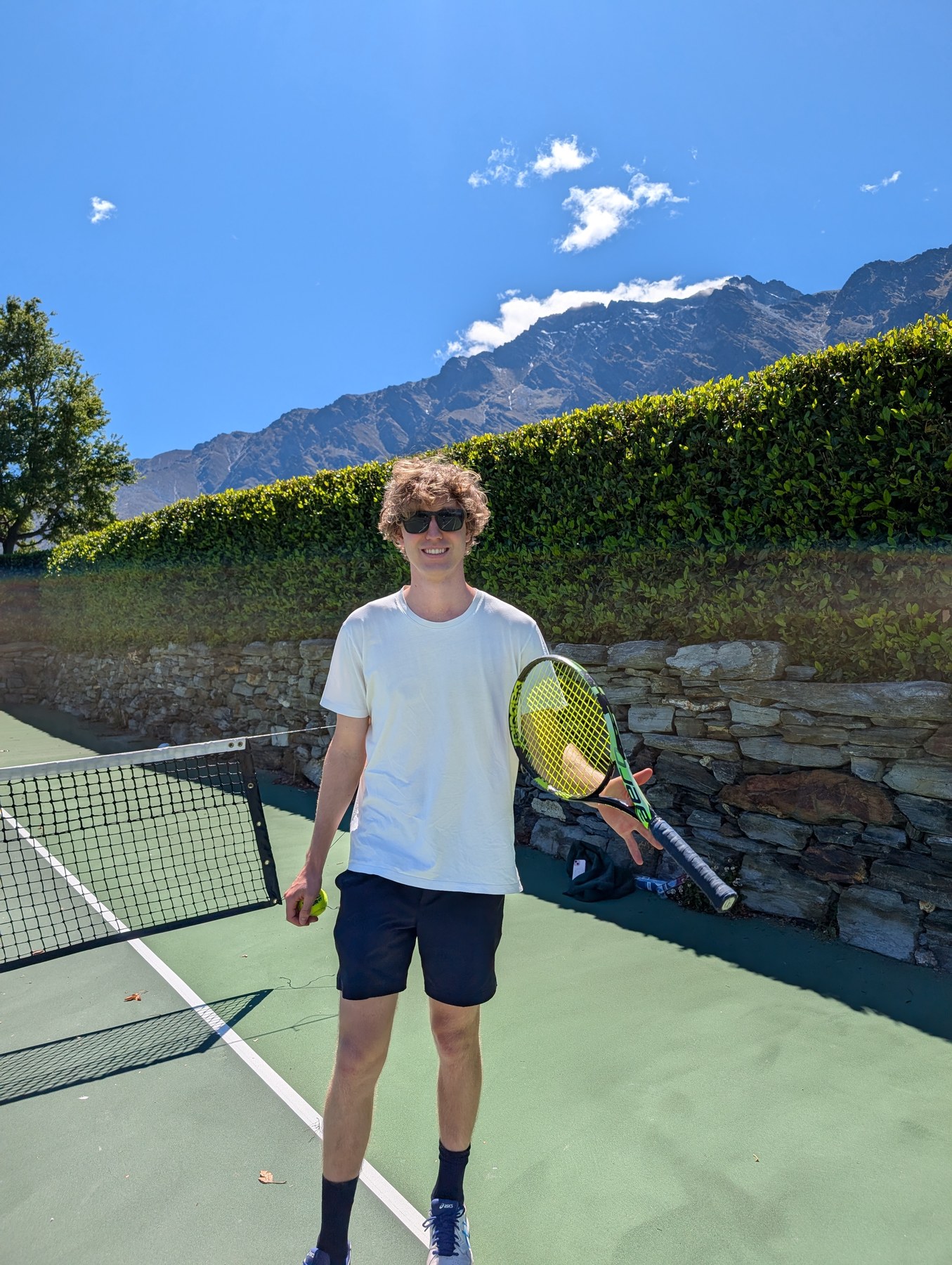 Matt Edwards standing on court holding a racquet and a ball